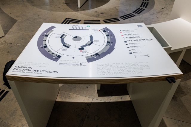 Ansicht eines Ausstellungstisches mit dem Ausstellungsplan zur Orientierung